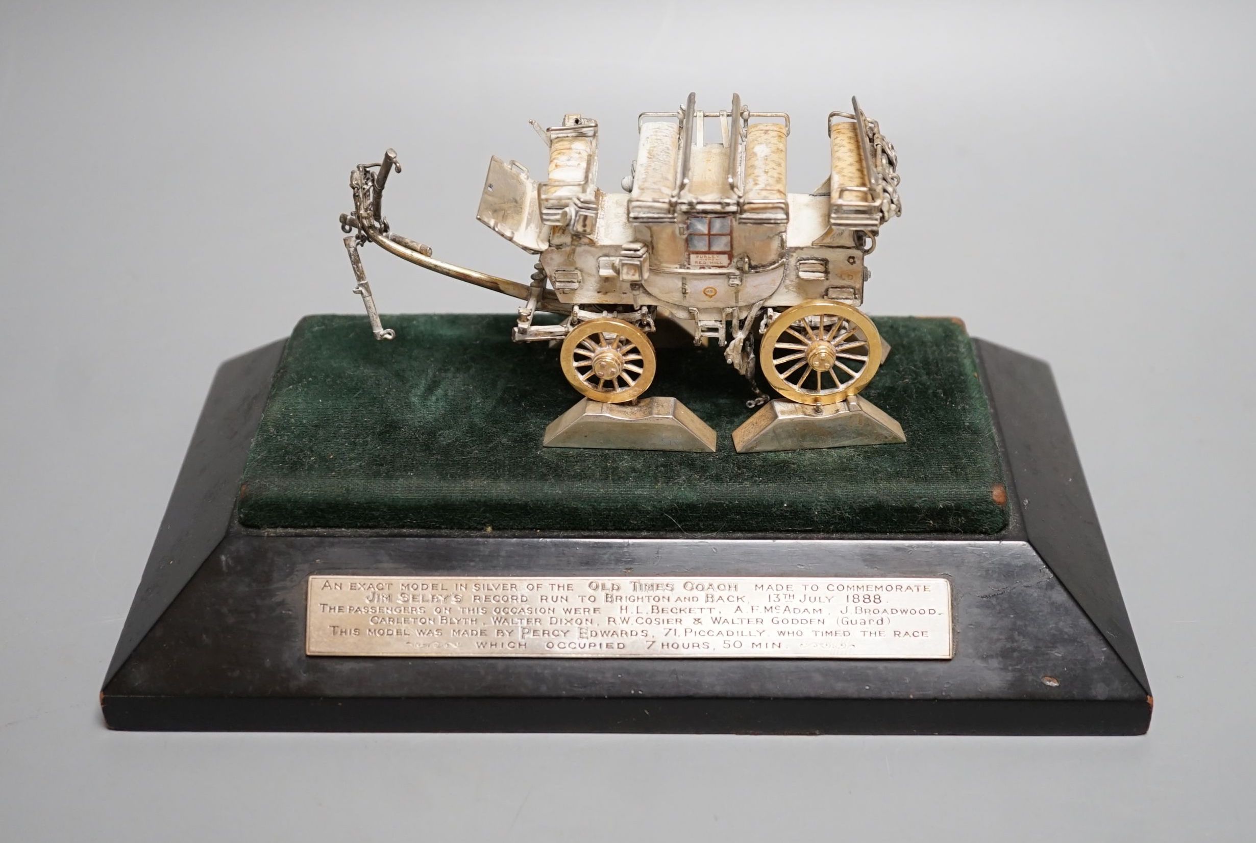 A parcel gilt white metal and enamelled miniature model of 'The Old Times Coach Made To Commemorate Jim Shelby's Record Run To Brighton and Back, 13th July, 1888', on plinth base with engraved inscription, overall 12.8cm